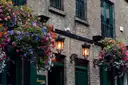 The front of a Dublin pub with hanging flower baskets and lanterns