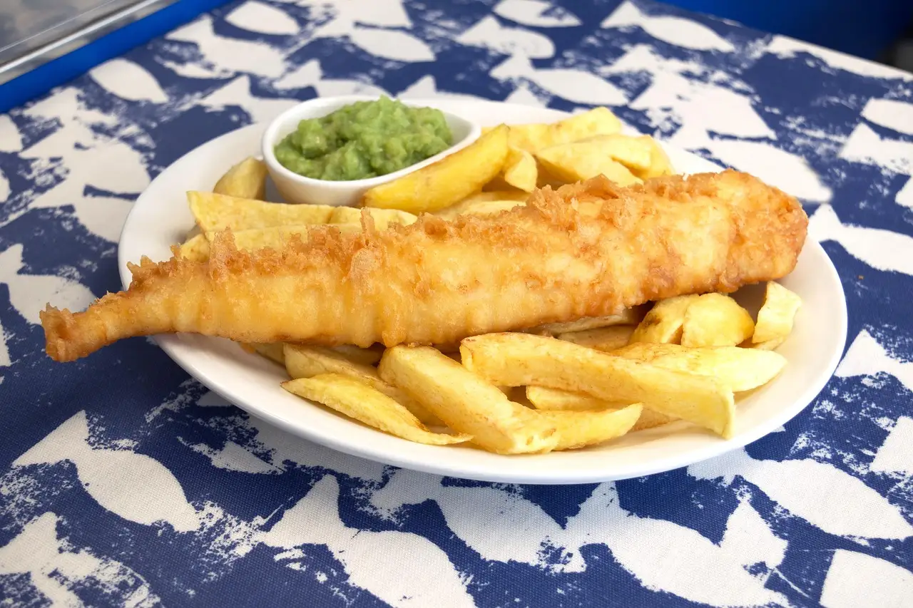 Battered fish with chips and mushy peas on a plate, a classic Irish pub dish (generic food photo, not a named restaurant)