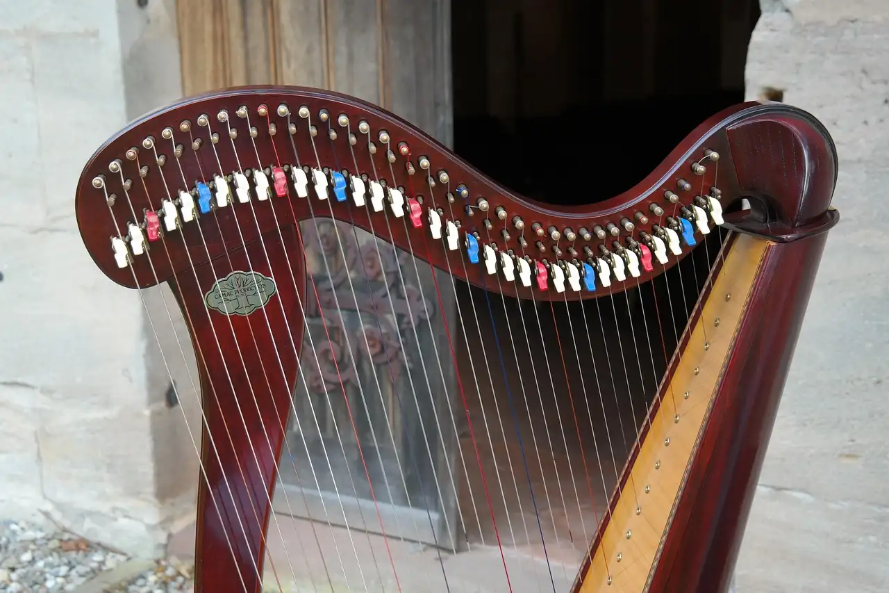 A wooden Celtic harp with coloured string pegs