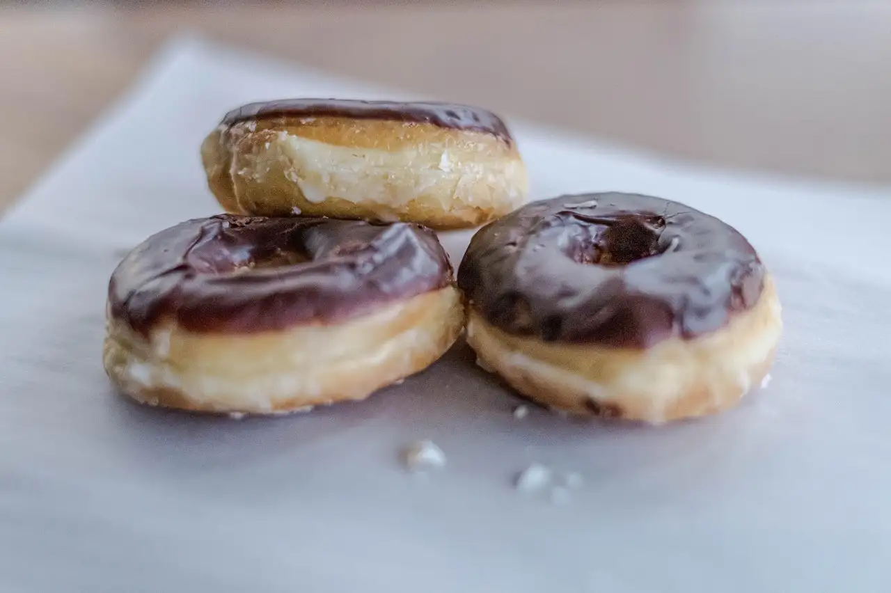 Three chocolate-glazed doughnuts on paper