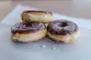 Three chocolate-glazed doughnuts on paper