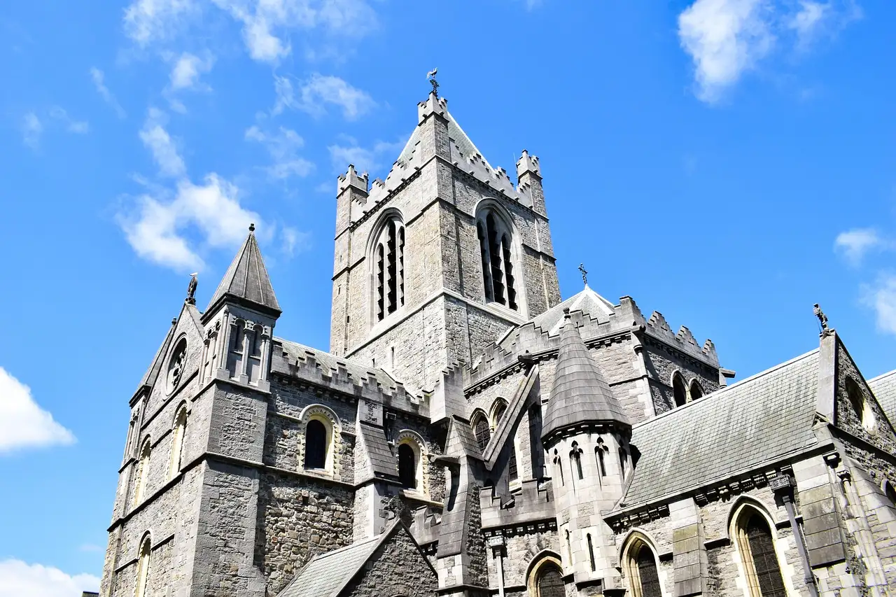The stone tower and pinnacles of Christ Church Cathedral in Dublin against a blue sky