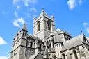 The stone tower and pinnacles of Christ Church Cathedral in Dublin against a blue sky
