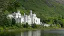 Kylemore Abbey on a lake in Connemara, County Galway (the region the bus leaves from; no photo of the coach itself)