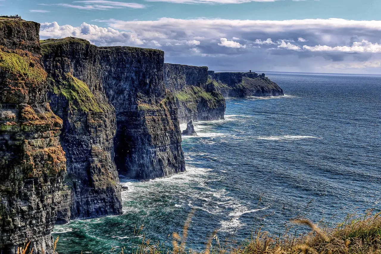 The Cliffs of Moher dropping into the Atlantic, with the cliff line running into the distance