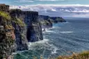 The Cliffs of Moher dropping into the Atlantic, with the cliff line running into the distance