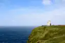 O'Brien's Tower on a green clifftop at the Cliffs of Moher, high above the sea