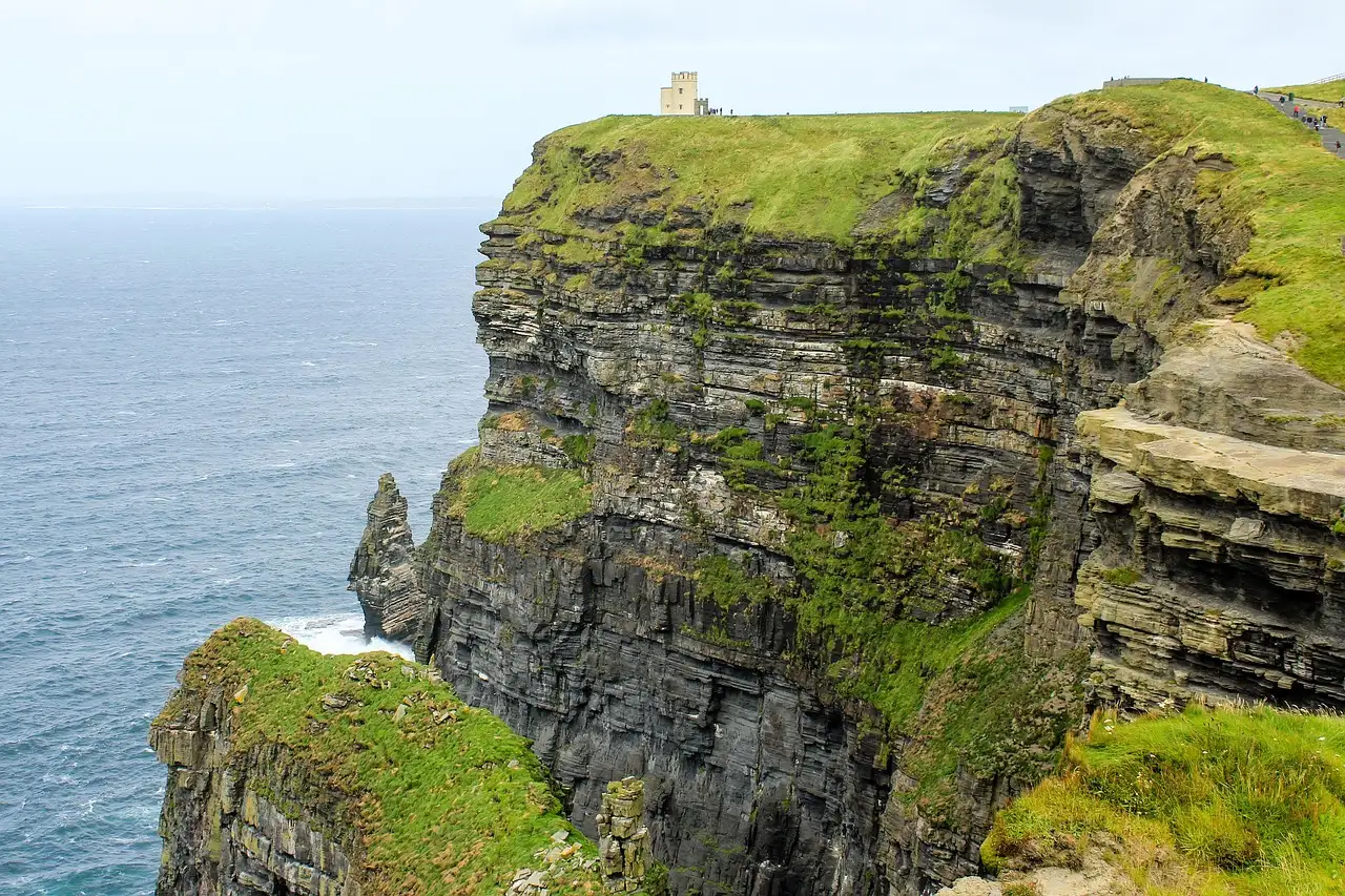 O'Brien's Tower on a green clifftop at the Cliffs of Moher, with the sea far below