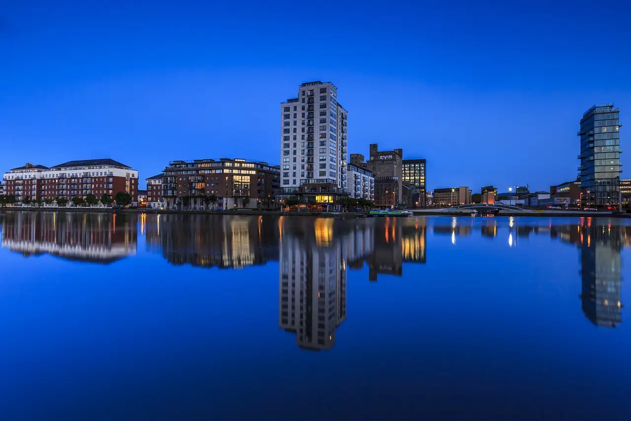 Dublin Docklands at blue hour, with lit buildings reflected in the still water of the river