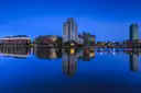 Dublin Docklands at blue hour, with lit buildings reflected in the still water of the river