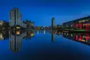 Dublin's Docklands at blue hour, with modern buildings reflected in still water