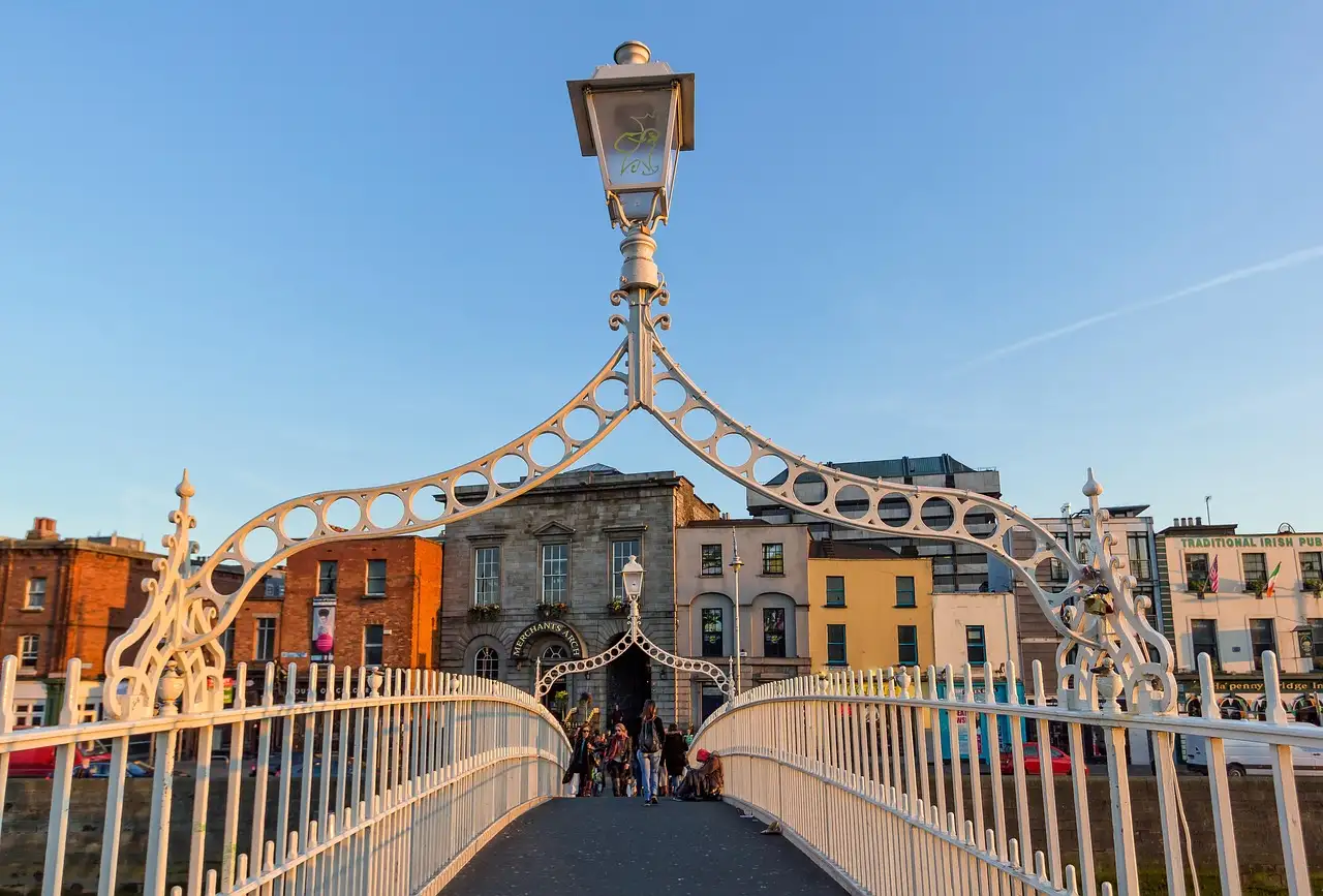 The Ha'penny Bridge in Dublin in evening sun, looking along the deck under one of its iron lamp arches