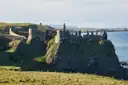 The ruins of Dunluce Castle on a cliff above the sea