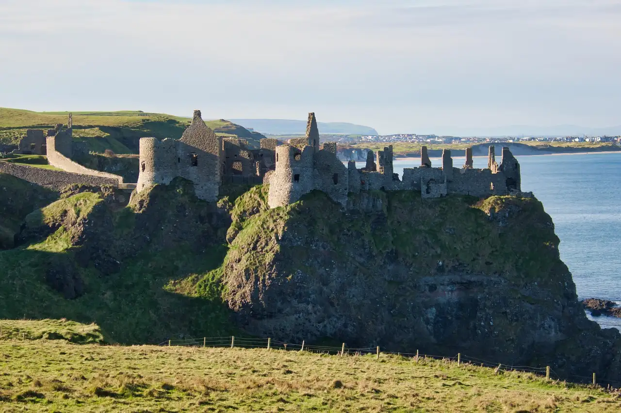 The ruins of Dunluce Castle on a cliff above the sea