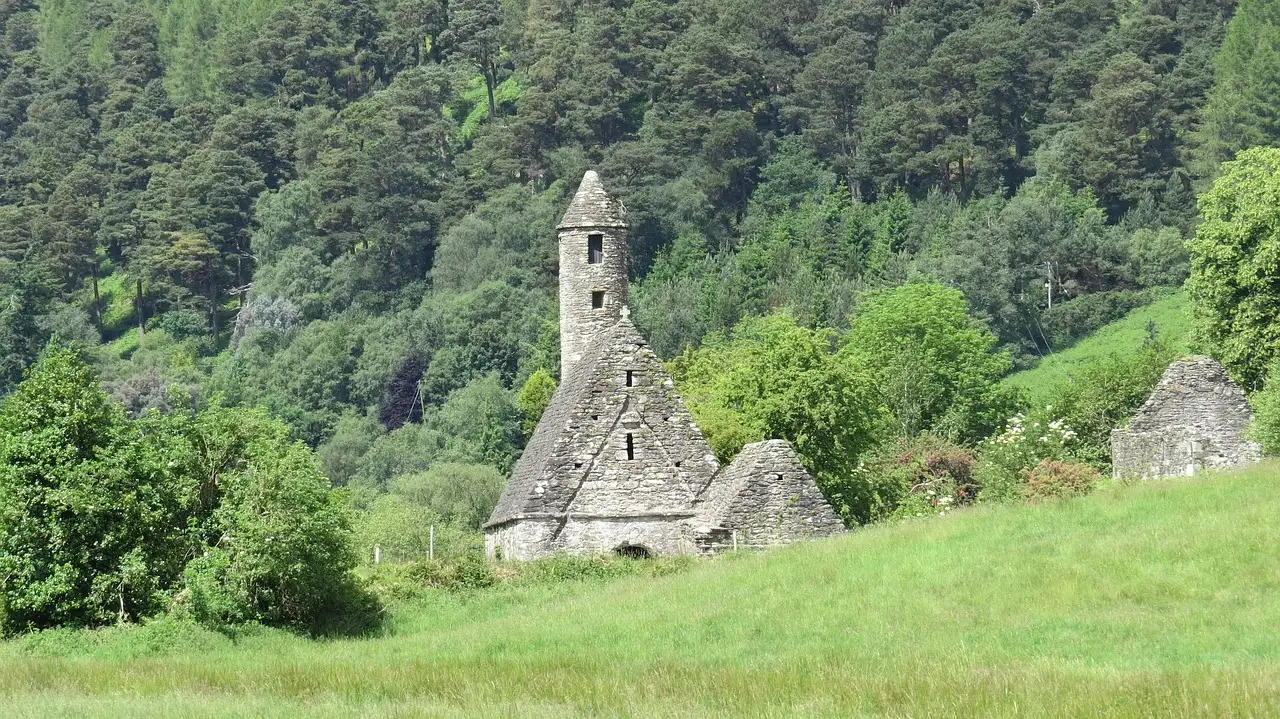 St Kevin's Church, a small stone church with a round belfry, in the green Glendalough valley