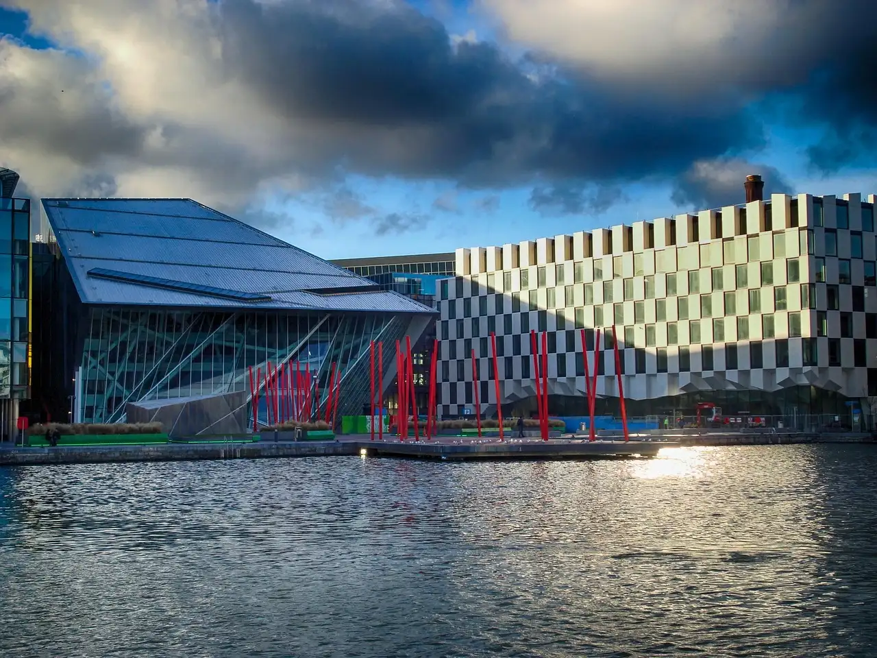 The Grand Canal Dock in Dublin with modern buildings and red poles by the water