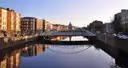 The Ha'penny Bridge over the River Liffey in evening light, with the quay buildings reflected in the water