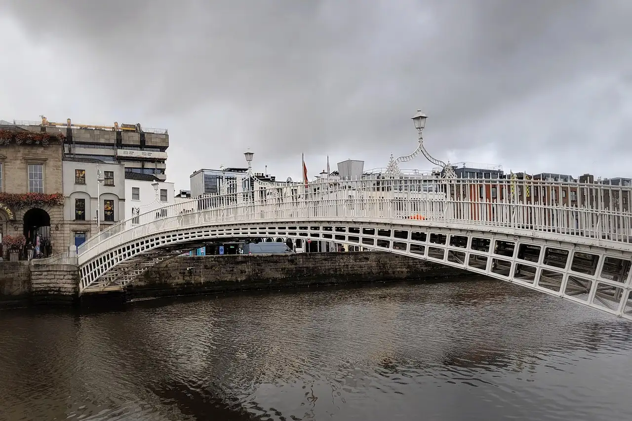 The white iron Ha'penny Bridge over the River Liffey in Dublin on a grey day