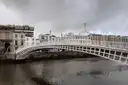 The white iron Ha'penny Bridge over the River Liffey in Dublin on a grey day