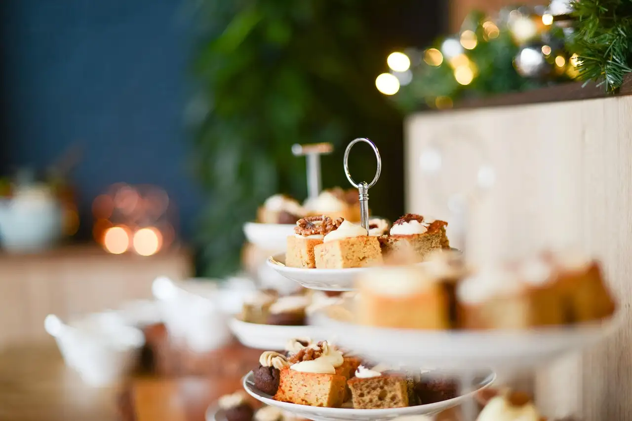 Cakes on a tiered stand with fairy lights blurred behind