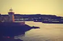 The lighthouse at the end of the pier in Howth harbour in warm evening light