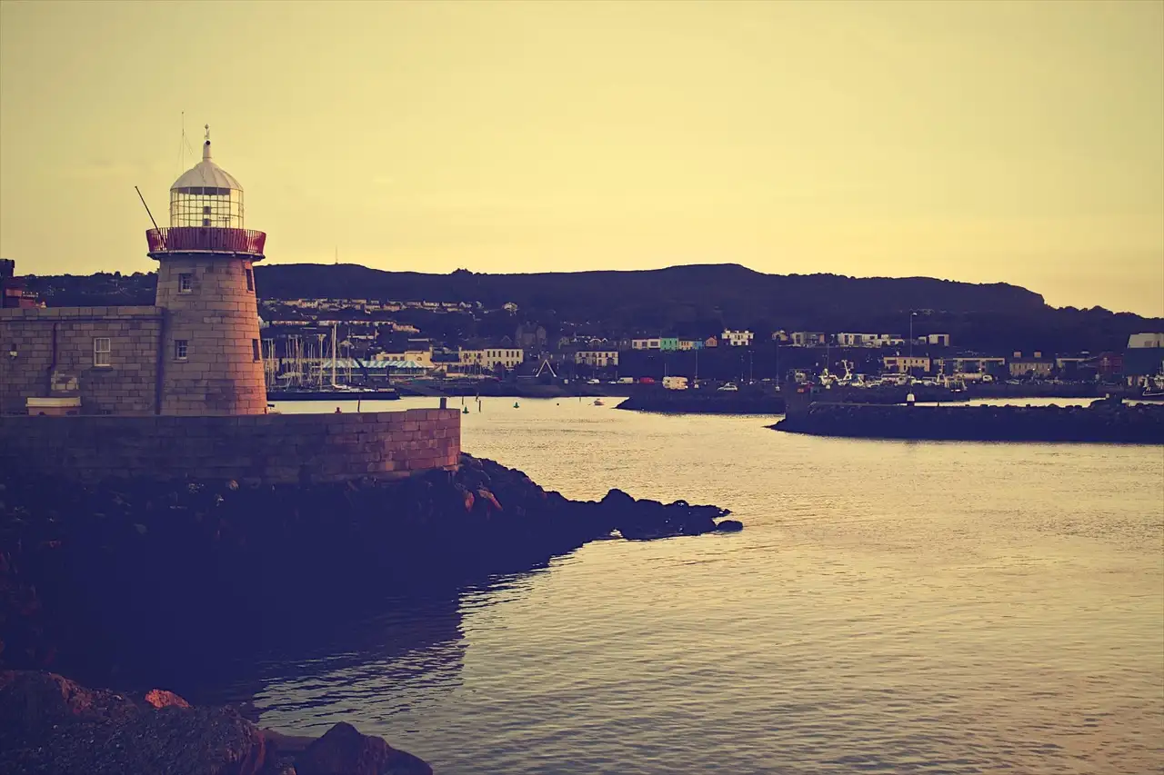 The lighthouse at the end of the pier in Howth harbour in warm evening light