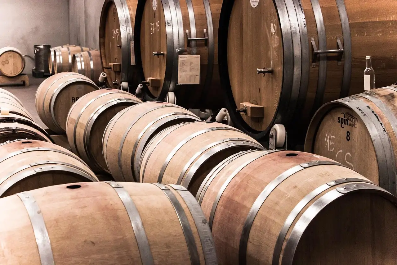 Wooden wine and whiskey barrels lined up in a cellar