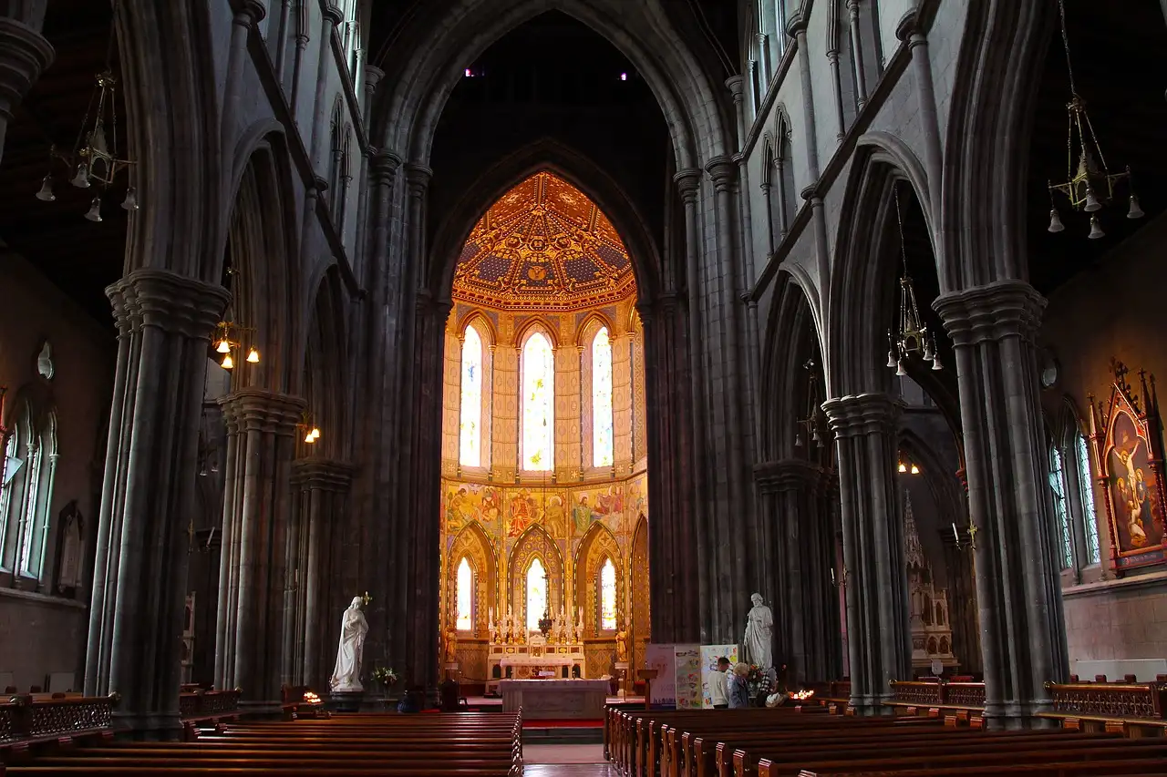 The nave of St Mary's Cathedral in Kilkenny, with stone arches and a lit altar