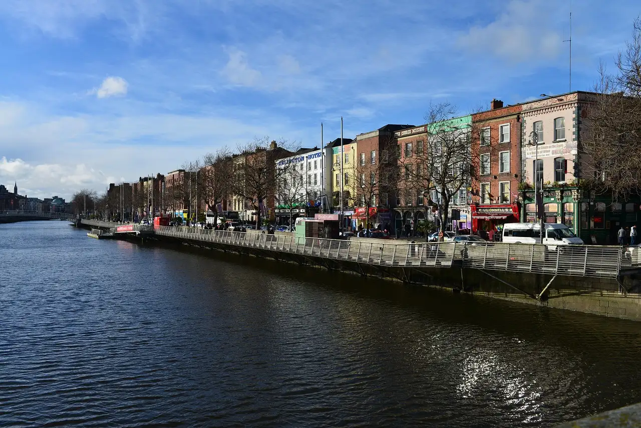 The River Liffey in Dublin in afternoon sun, with a row of quay buildings along the far bank