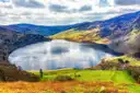Lough Tay, a dark lake with a pale beach, below the Wicklow hills