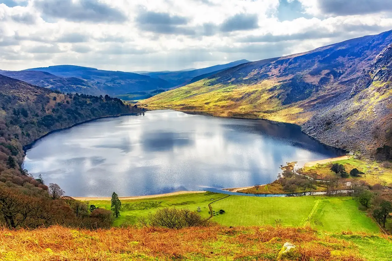 Lough Tay, a dark lake with a pale beach, below the Wicklow hills