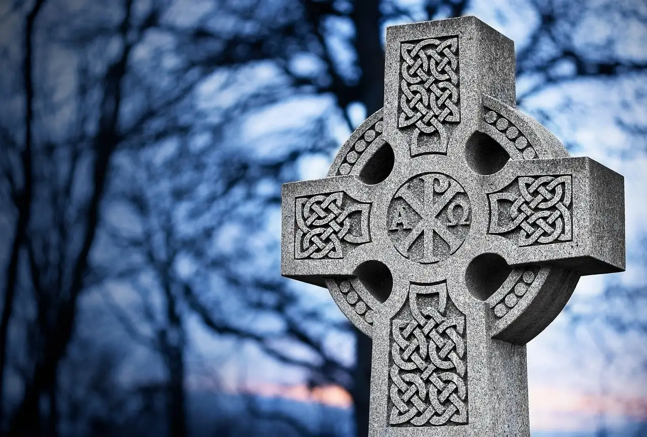 A carved Celtic high cross at dusk (a stand-in for the museum's early-Irish collections; no photo of the museum itself)