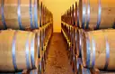 Rows of oak casks on both sides of a narrow aisle