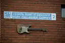 The Rory Gallagher Corner street sign with a guitar on a brick wall in Temple Bar