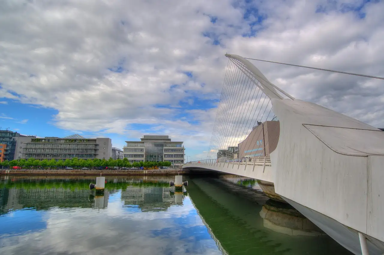The white Samuel Beckett Bridge over the River Liffey under a cloudy sky