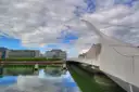 The white Samuel Beckett Bridge over the River Liffey under a cloudy sky