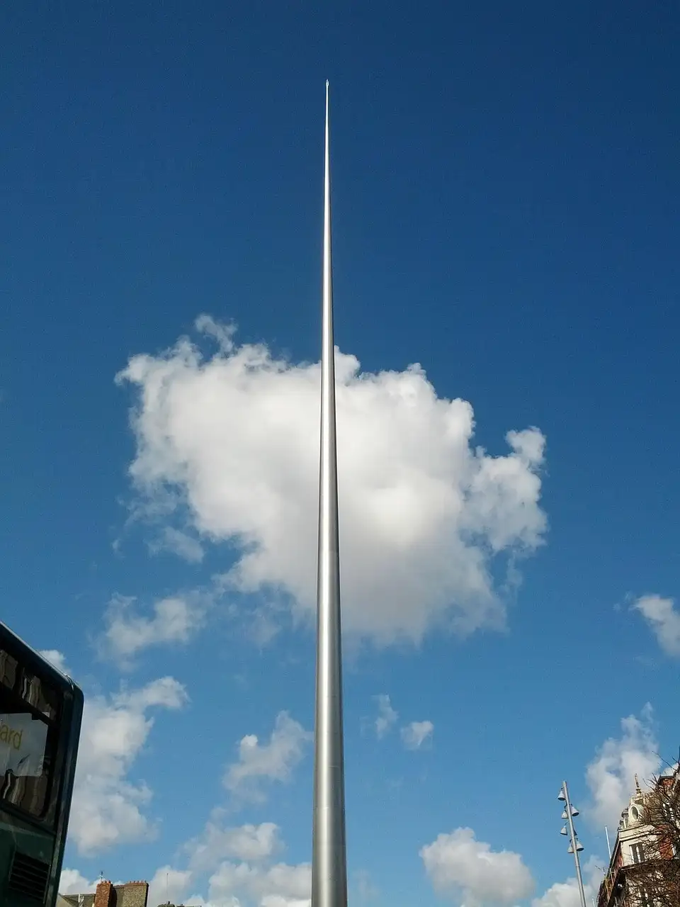 The tall steel Spire on O'Connell Street in Dublin against a blue sky with white clouds
