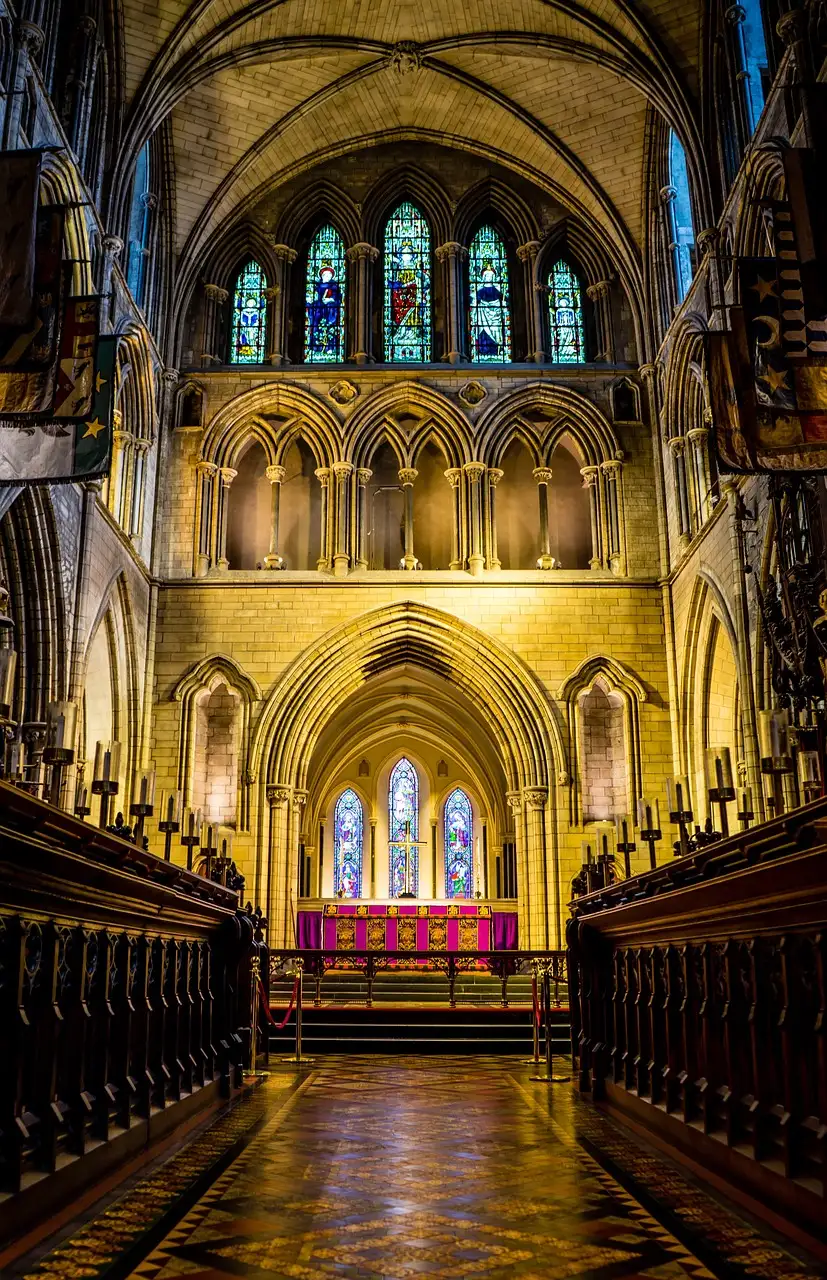 Inside St Patrick's Cathedral: carved wooden choir stalls, a tiled floor and tall stained glass windows above the altar