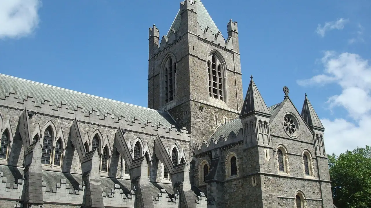 A grey stone church tower with pinnacles in Dublin, seen from below