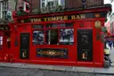 The red front of The Temple Bar pub on a cobbled corner in Dublin