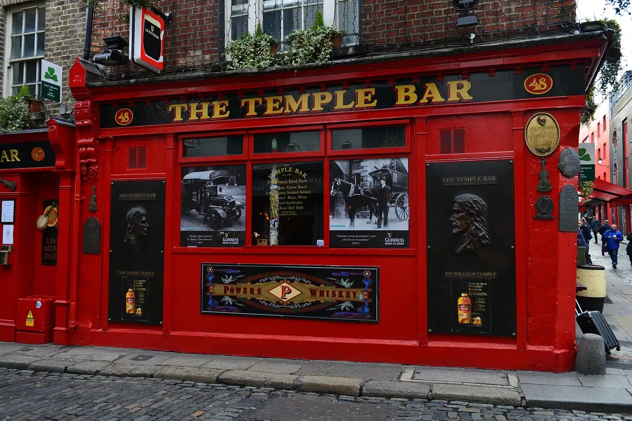 The red front of The Temple Bar pub on a cobbled corner in Dublin