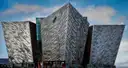 The angular, metal-clad Titanic Belfast building under a blue sky