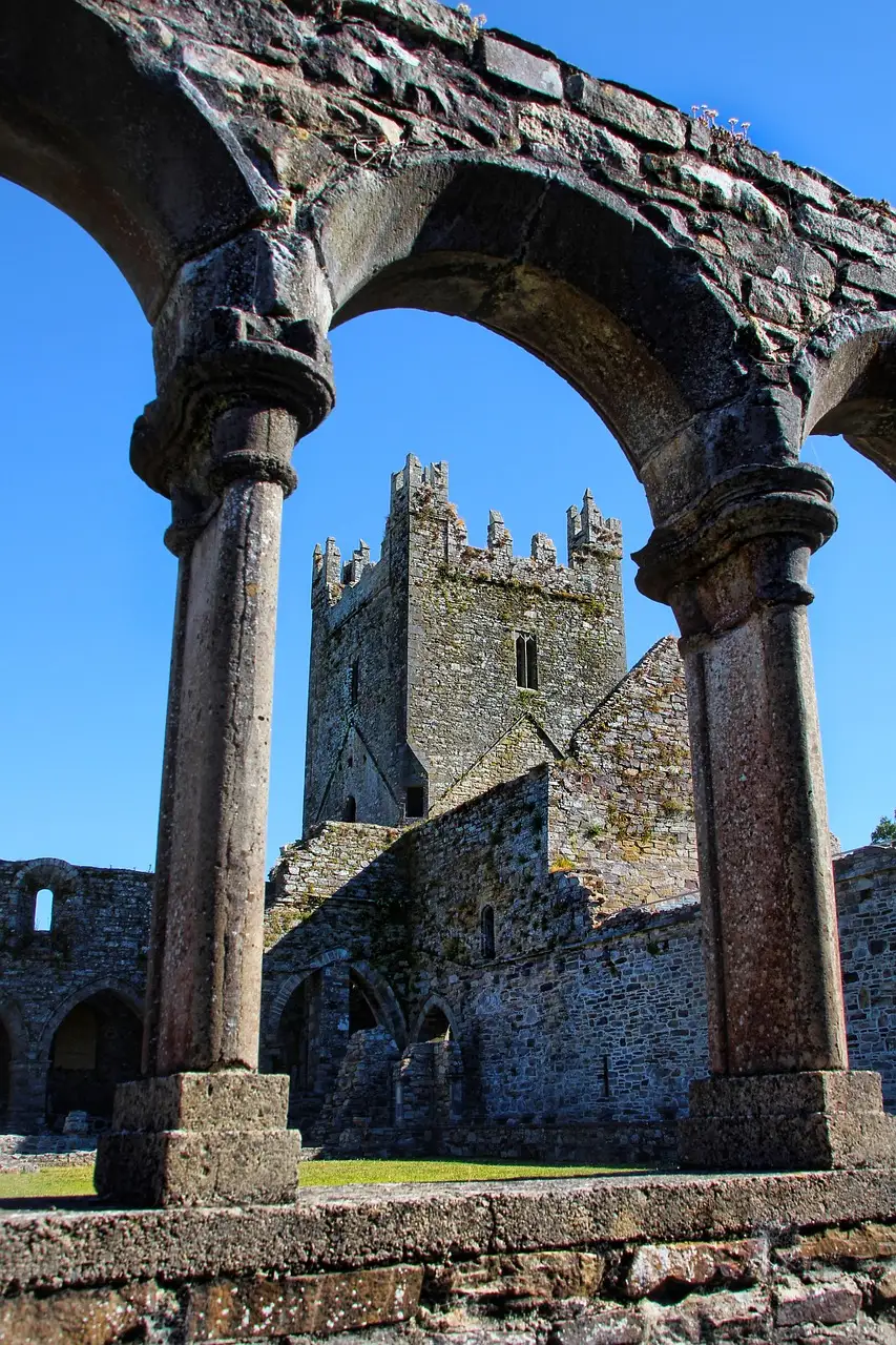 Ruined arches and tower of Jerpoint Abbey in County Kilkenny, seen through a stone arcade (a sight near the line's destination; no photo of the train itself)